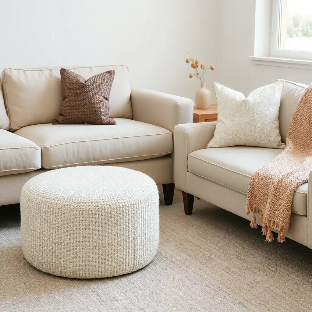Boucle fabric ottoman in a cozy living room with soft throws and natural light