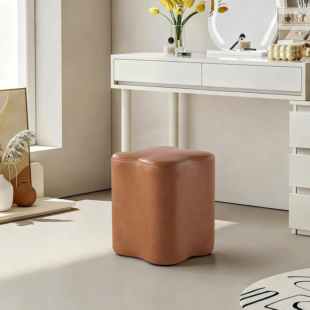Clover Leather Ottoman with a six-petal flower silhouette in smooth, premium saddle-tan faux leather.